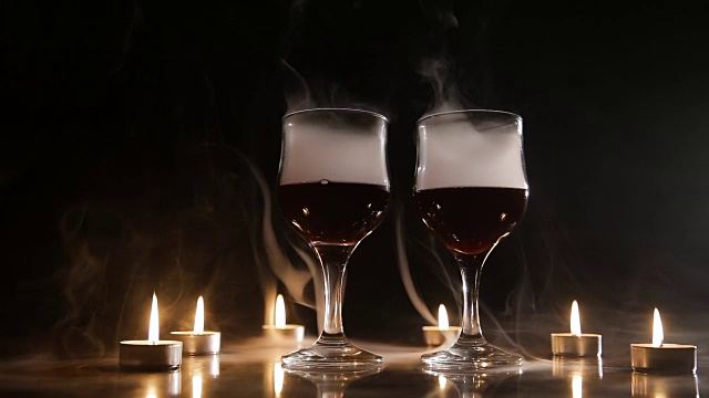 酒杯和燃烧的蜡烛在烟雾中视频下载