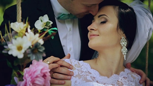 可爱的新婚夫妇鲜花的秋千视频下载