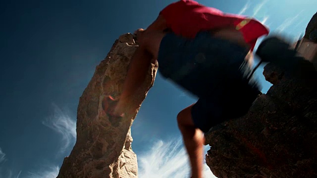 抱石攀岩者悬在蓝天下的极端悬垂下视频素材