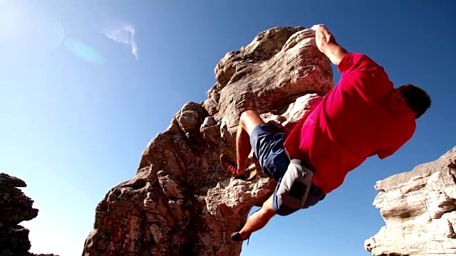 极端自由攀爬的人挂在岩石上的低角度视频素材