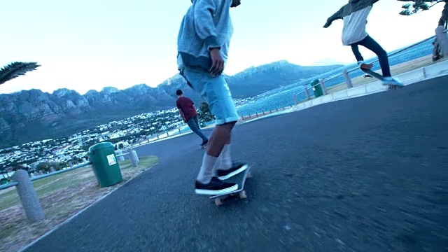 多民族溜冰者在海滩的街道上滑冰视频素材