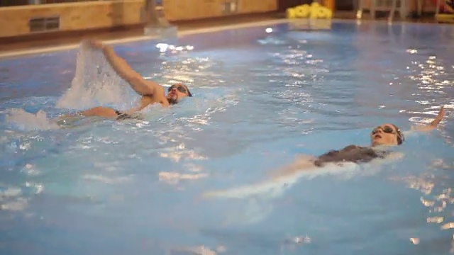 男人和女人在游泳池里游泳视频下载