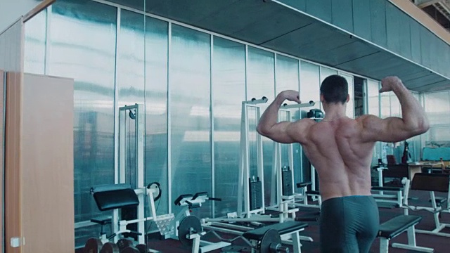 运动员在健身房镜子旁边摆姿势视频素材