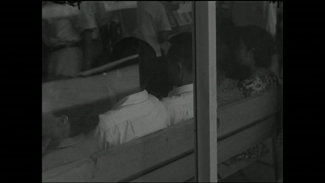 男人和女人休息在一个建筑的窗户上展示一个空调的广告。视频素材