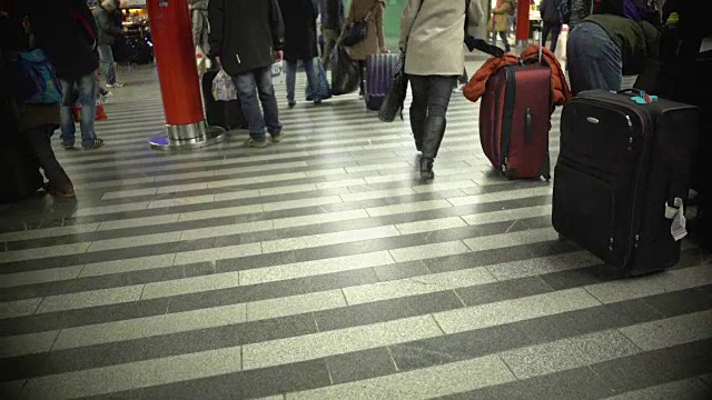 许多人带着行李行走，忙碌的乘客在机场或视频素材