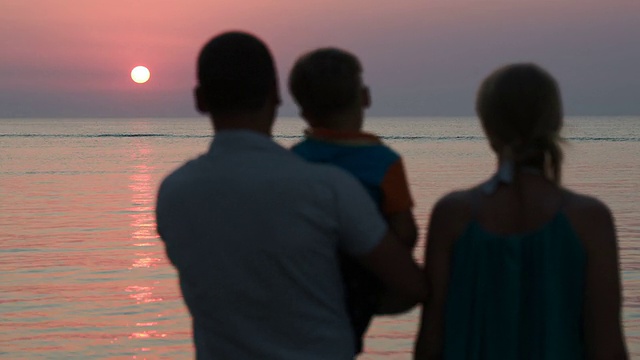 一家三口在看海上日落视频素材