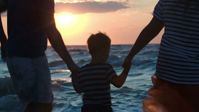 幸福的三口之家在日落的海上跳舞视频素材
