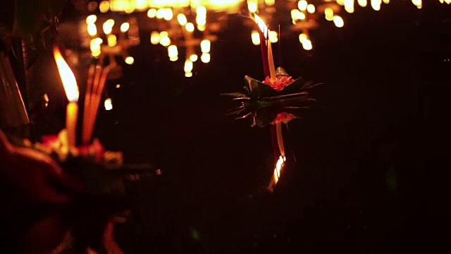泰国清迈的水牛节。手放开浮动的装饰篮子和蜡烛视频下载