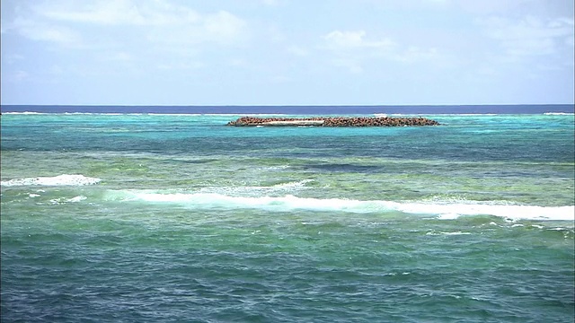 浅绿色的海水包围着日本冲之鸟岛的北小岛。视频素材