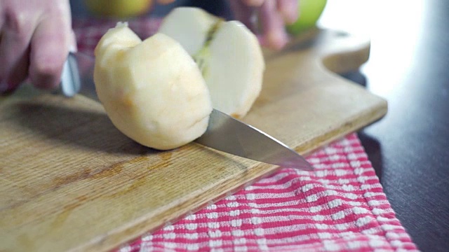 厨师在厨房的木板上切去皮的苹果。苹果片视频素材