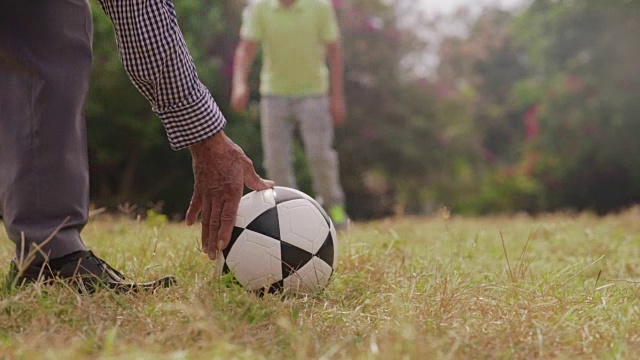 爷爷和男孩一起踢足球视频素材