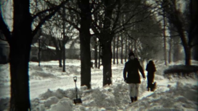 1936年:暴风雪过后，孩子们在铲人行道上的雪。视频素材