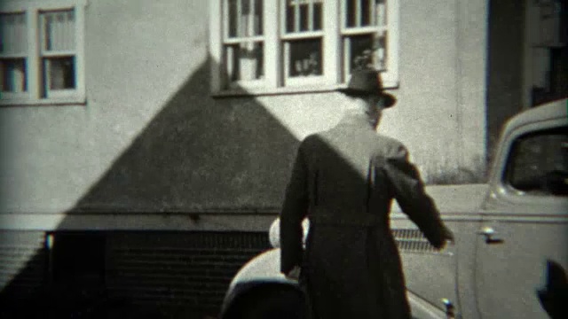 1936年:一名男子将一辆1934年福特车型的汽车倒出车道。视频素材