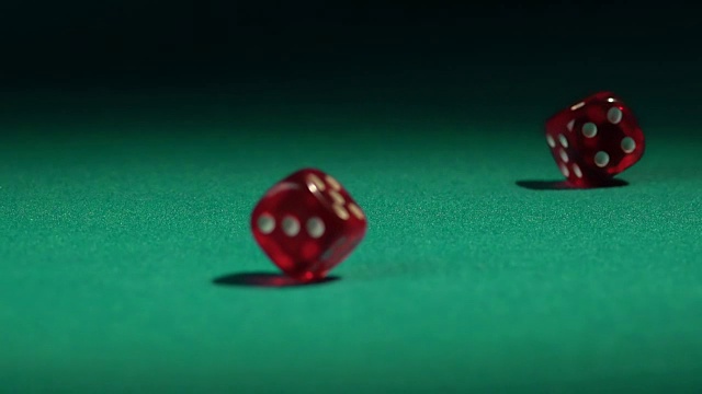 特写的骰子落在绿色赌场的桌子上，打赌视频素材
