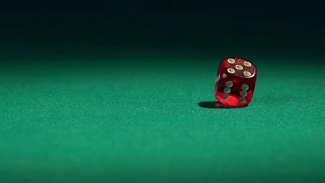 近距离观看红色赌场骰子滚动在绿色的表面视频素材