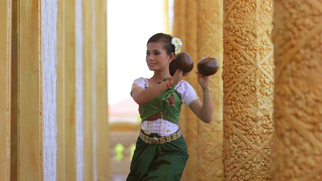美丽的亚洲女孩在寺庙里表演椰子民间舞蹈视频下载