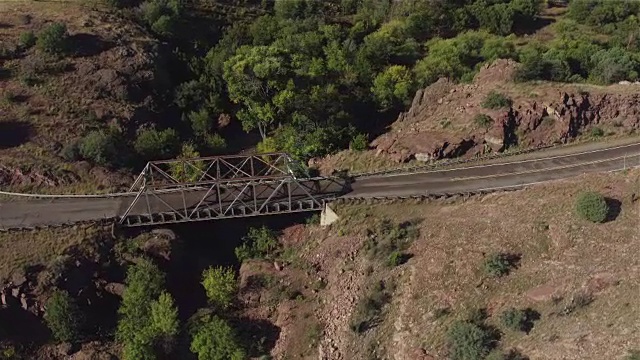 岩石沙漠中的乡村公路和干河峡谷桥视频素材