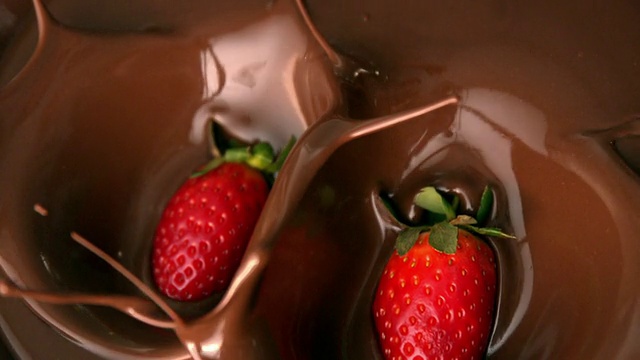 草莓落入融化的巧克力中视频素材