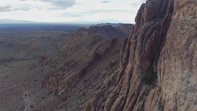 天线:在广阔的沙漠中飞过岩石山壁视频素材