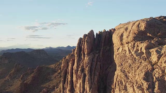 航拍:飞过岩石山顶，向沙漠山谷飞去视频素材