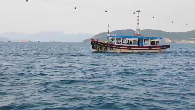 越南芽庄湾的旅游摩托艇。背景是Vinpearl缆车的柱子。从移动的船上看到的景色视频下载