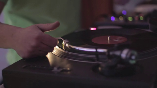 音响设备上，男DJ按混音键，播放黑胶唱片视频素材