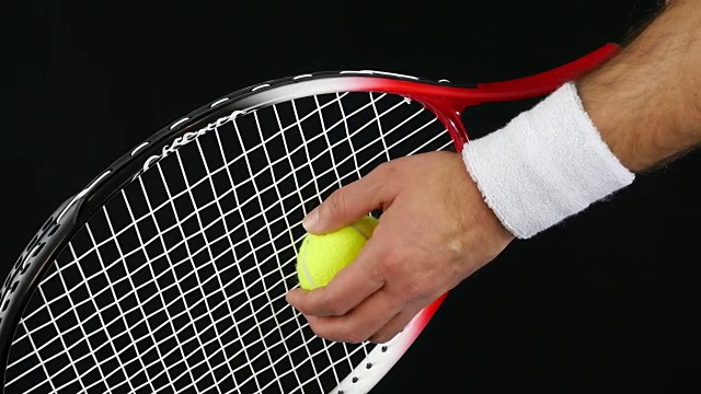 网球运动员准备用球拍击球，黑色背景视频下载