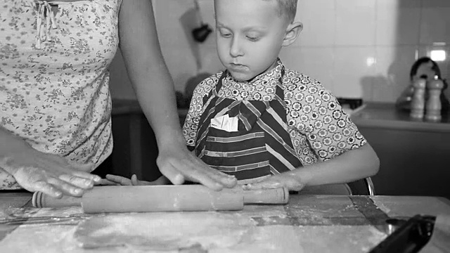 母亲和儿子做面团做蛋糕的黑白镜头视频素材