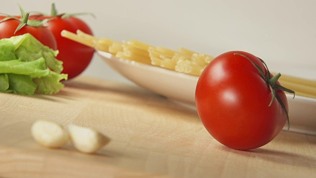 桌上放着成熟的番茄卷，旁边是意大利面和大蒜视频素材