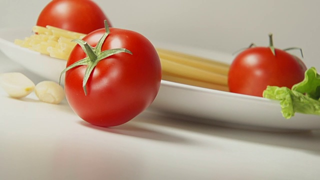 意大利面旁边的桌子上有红番茄卷视频素材