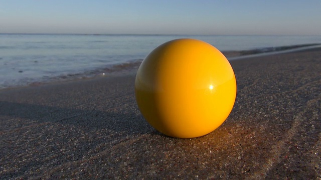 夏日海滨度假沙滩上的黄色台球视频下载