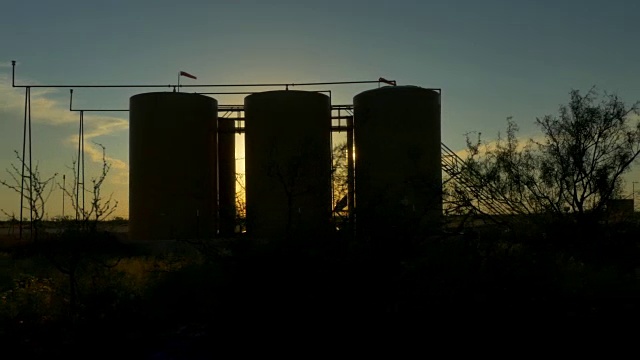 夕阳照耀着大油泵和储油罐视频素材