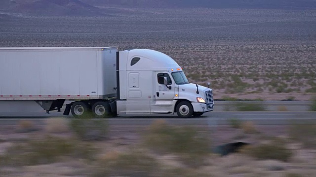 特写:货运半挂车在空旷的公路上行驶和运输货物视频素材