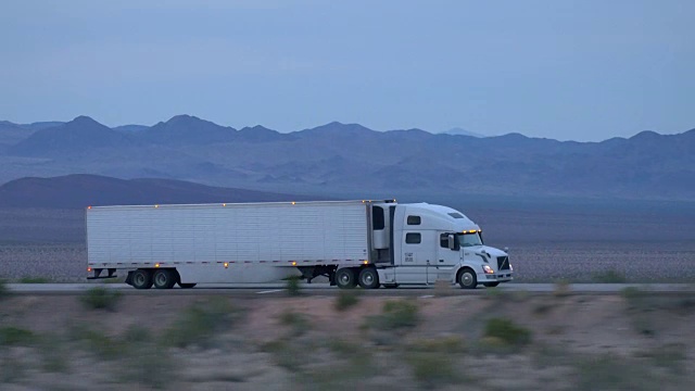 特写:货运半挂车在空旷的公路上行驶和运输货物视频下载