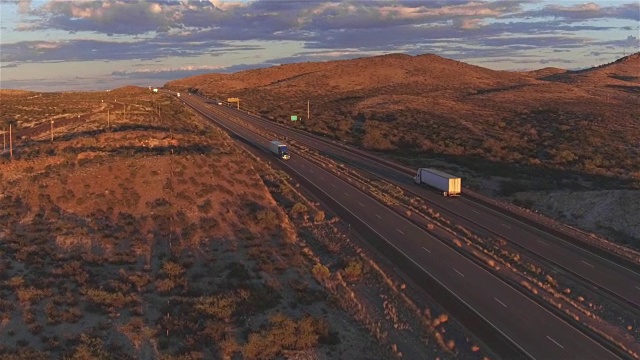 航拍:在繁忙的高速公路上，在运输货物的集装箱半挂车上方飞行视频素材