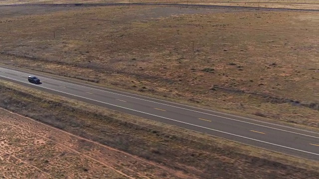 图片:在阳光明媚的夏天，一辆SUV行驶在空旷的乡村道路上视频素材
