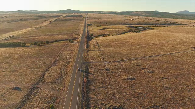 照片:日落时分，一辆SUV行驶在空旷的乡村道路上视频素材