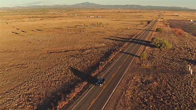 图片:日落时分，一辆SUV行驶在空旷的乡村道路上视频素材