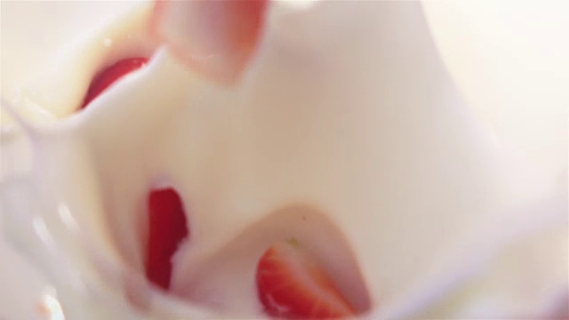 两段草莓落入酸奶的视频——非常慢的动作视频素材