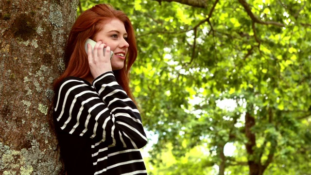 在公园里打电话的红发美女视频素材