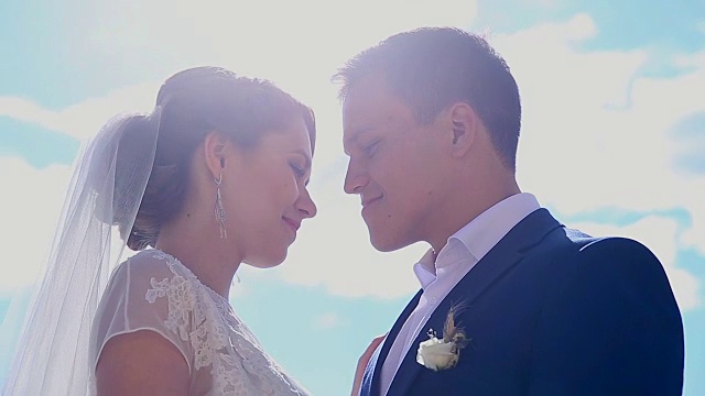 一对美丽的恋爱中的年轻夫妇刚刚在阳光下结婚接吻视频素材