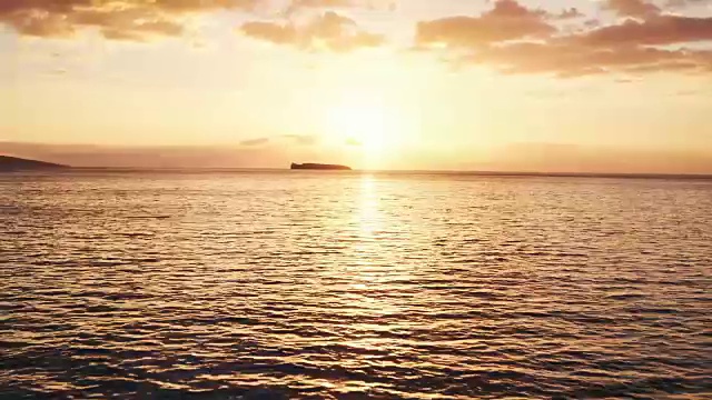 鸟瞰图飞越海洋进入惊人的日落视频素材