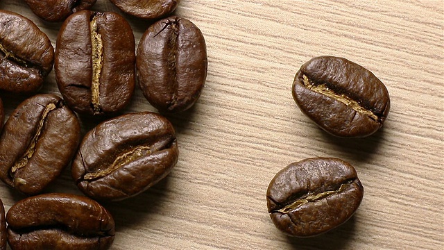 咖啡豆从黑暗中冒出来。移动的阴影。视频下载