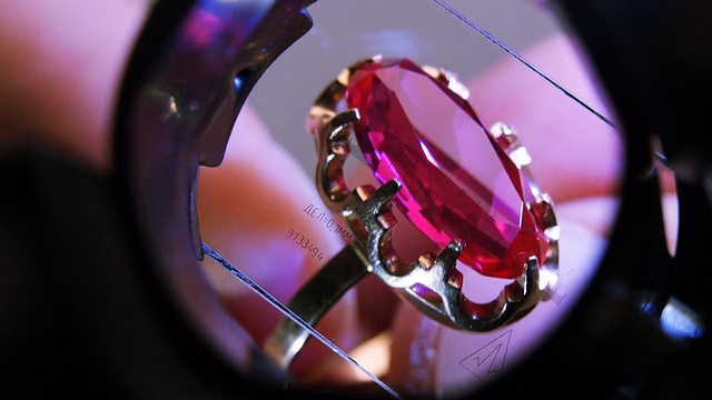 一枚镶有红宝石的金戒指穿过量杯视频下载