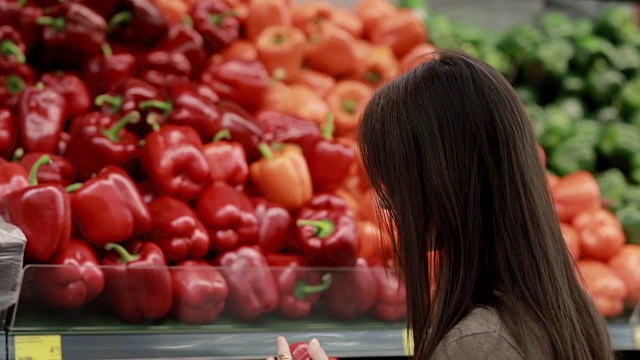 年轻女子在商店货架上选择红辣椒视频素材