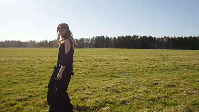 漂亮的女孩穿着黑色长裙走在操场上视频下载