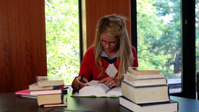 微笑的成熟的学生从她的书抬头视频下载