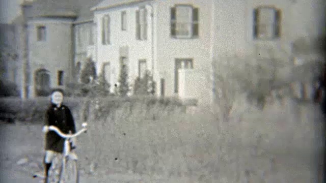 1937年:富家女骑着自行车经过豪宅。视频素材