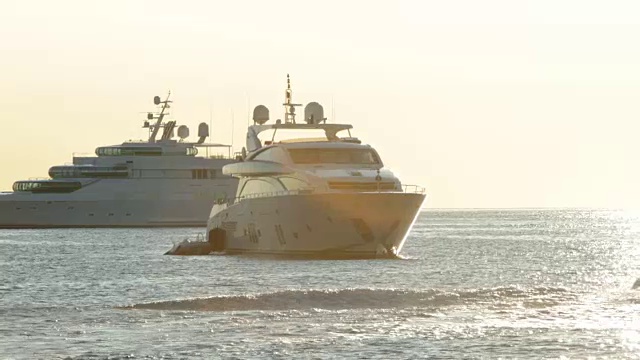 日出时分，在法国里维埃拉的圣让角费拉港，摩托艇在游艇前面视频下载