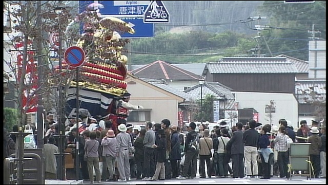 在日本Karatsu市，狮子脸花车经过一群观众。视频素材